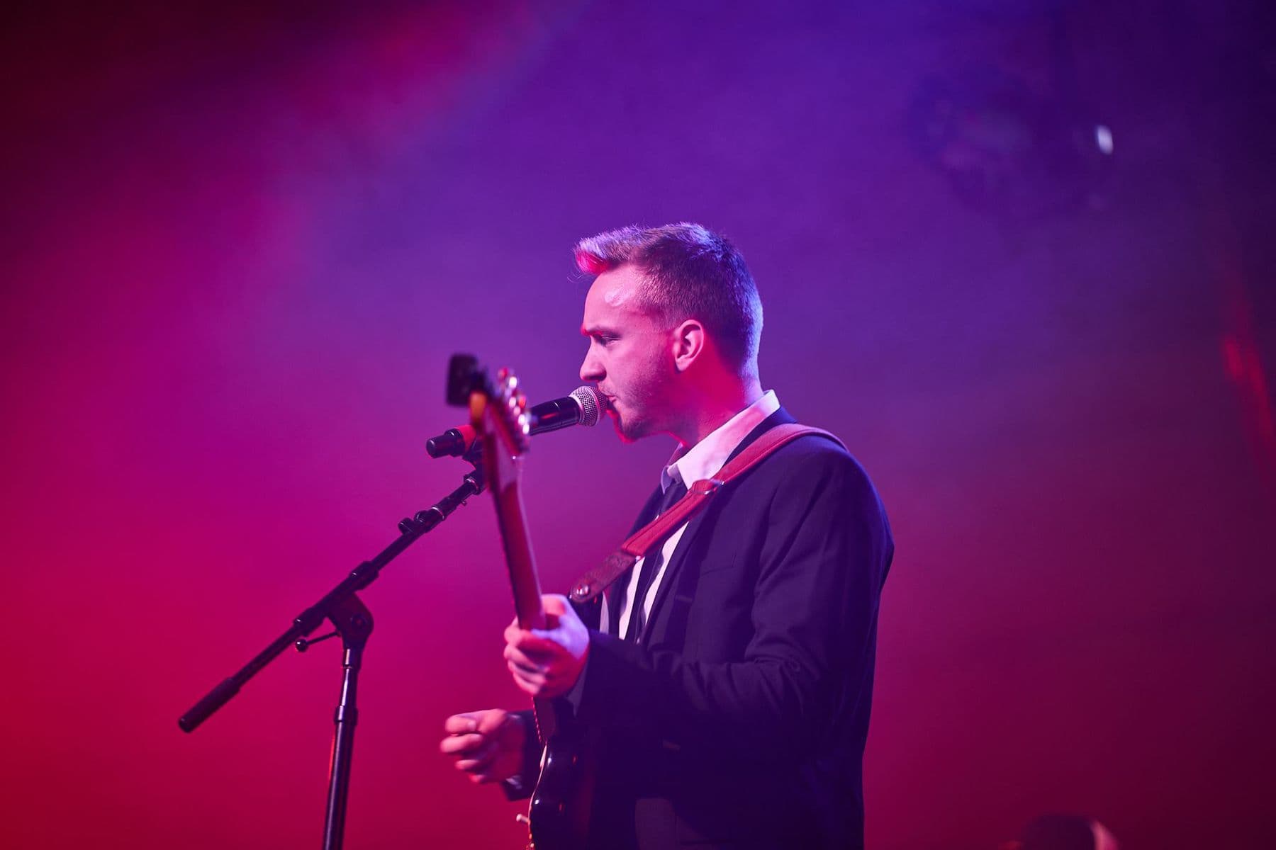 Aaron playing guitar on stage